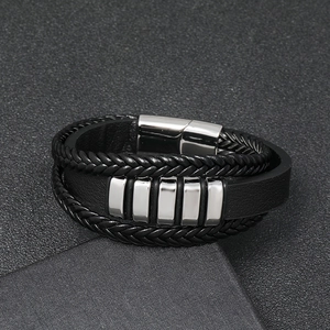 Macro shot of multi-layer black braided leather bracelet with silver stainless steel clasp