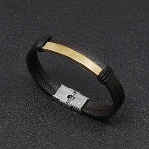 Detail of lychee textured leather bracelet with gold stainless steel and silver clasp