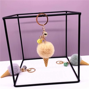 Detail of plush ice cream keychain with fluffy pompom cone and gold tassel charm