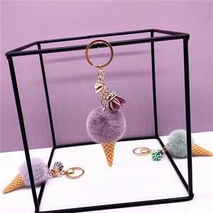Detail of cute plush ice cream keychain with colorful fur balls and golden heart charm