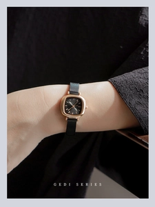 Detail of GEDI square gold watch with black dial and mesh strap on woman's wrist