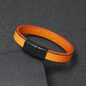 Detailed view of the orange leather bracelet with a matte black magnetic metal clasp