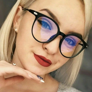 Close-up of black round metal glasses frame with anti-blue light lenses on a female model