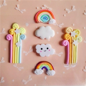 Flat lay of polymer clay rainbow and cloud charms for DIY necklace and keychain making