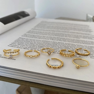 Detailed view of seven gold 925 sterling silver rings with diverse geometric designs