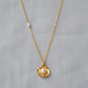 Elegant gold shell pendant necklace with white freshwater pearls on a delicate chain