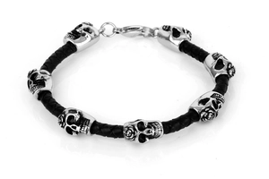 Detailed macro of braided black leather bracelet with six metallic skull rose charms