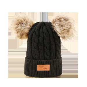 Black knit children's beanie with two faux fur pom-poms and leather logo patch