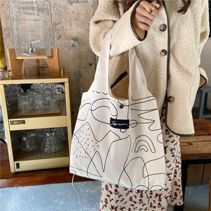 Detail of minimalist cream canvas tote bag with black abstract art and snap closure