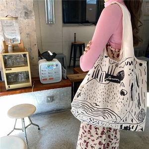 Detail of minimalist cream canvas tote bag featuring modern artistic graffiti illustration