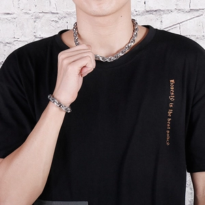 Close-up of men's chunky silver stainless steel chain necklace and bracelet set on model