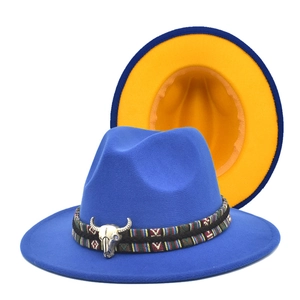 Detail of blue fedora featuring ethnic band and silver bull head accessory with orange brim