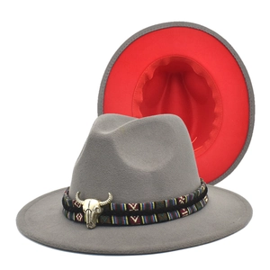 Detail of wool fedora hat with ethnic band, bull head charm, and contrast red brim interior