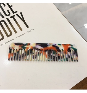 Detail view of a retro leopard print acetate hair comb on an artistic white magazine base