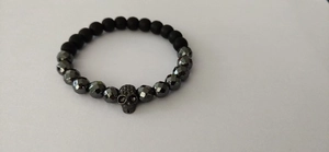 Men's 6mm frosted stone bead bracelet with a black skull charm on a white background