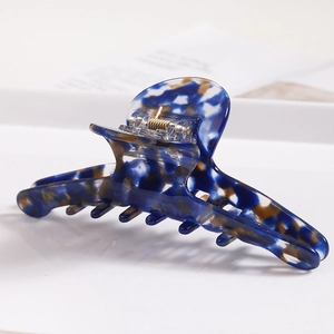 Detail of large acetate hair claw with marble texture and sturdy gold spring