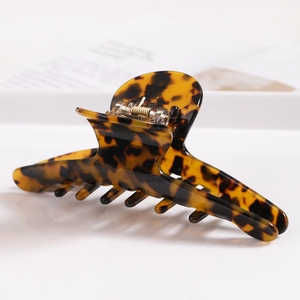 Close-up of tortoiseshell acetate hair claw clip showing polished leopard pattern and sturdy teeth