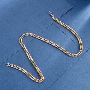 Close-up of two-tone silver and gold Cuban link chain with a secure lobster clasp