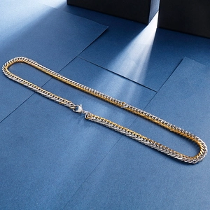 Detail of two-tone gold and silver curb chain necklace with secure lobster clasp