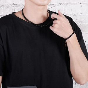Close-up of black titanium paperclip link chain necklace and bracelet on model