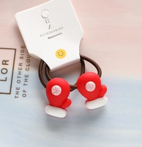 Detail of children's Christmas hair ties with cute red glove charms and brown elastic