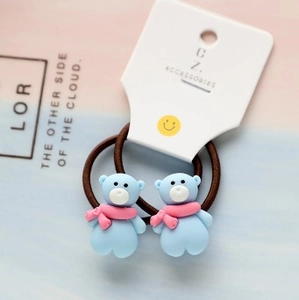 Detail of blue bear charms on brown elastic hair ties with festive pink scarf details