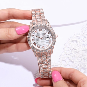 Dettaglio orologio in oro rosa con pavé di cristalli, numeri romani e datario a ore 3