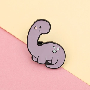 Close-up of a cute purple dinosaur enamel pin with creative cartoon dragon design
