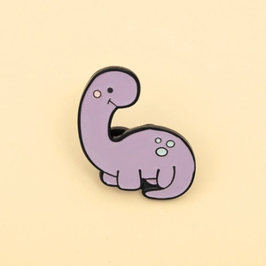 Close-up of a cute purple cartoon dinosaur enamel pin with light blue spots and black edges