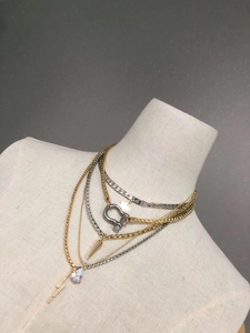 Detail view of layered gold and silver chain necklaces with lightning and crystal pendants