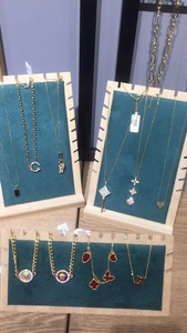 Bamboo necklace display stand featuring jewelry collection on green velvet surface