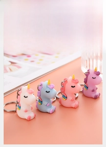 Set of four colorful cartoon unicorn keychains in white, blue, pink, and purple soft PVC