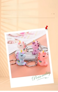 Creative polaroid style display of four colorful cartoon unicorn keychains for bags
