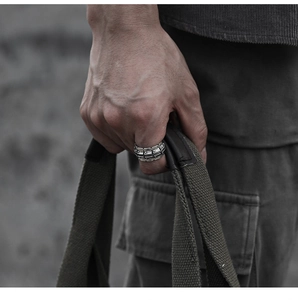 Detail of vintage silver motorcycle track ring on hand with cool streetwear styling