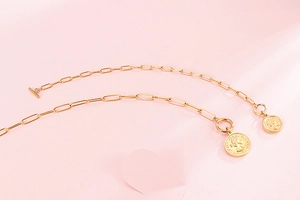 Vue détaillée de l'ensemble de bijoux dorés avec pendentifs reine Elizabeth et fermoirs T-bar