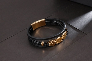 Close-up of black braided leather bracelet with golden skull charm and magnetic clasp