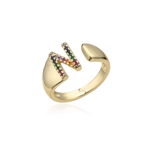 Macro shot of 18K gold letter N ring with colorful inlaid crystals and rainbow stones