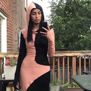 Detail view of pink and black color block hooded long dress with slim fit and long sleeves