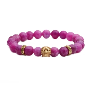 Bracciale in perle di agata viola da 8mm con ciondolo a teschio dorato su bianco