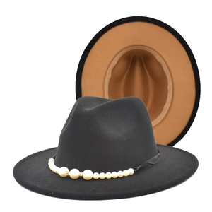 Détail d'un chapeau fedora en laine avec bord plat, perles blanches et design bicolore