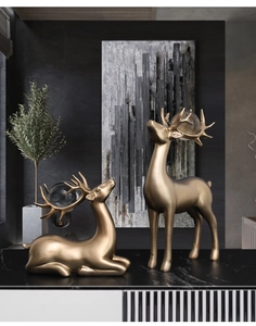 Detailansicht luxuriöser goldener Elchfiguren mit Kristallkugeln auf Marmorfläche