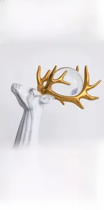 Detail der modernen Elch-Skulptur mit Marmorstruktur, Goldgeweih und Glaskristallkugel