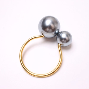 Detail of matte gold napkin ring with dual grey pearls in large and small sizes