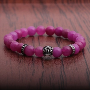 Retro 8mm rose red beaded skull bracelet with silver-tone spacers on wood background