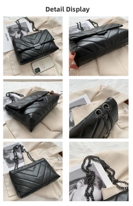 Detail of black quilted leather crossbody bag with V-shaped stitching and black chain strap