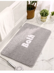 Close-up of gray non-slip bath mat with high-density tufted texture and Bath text