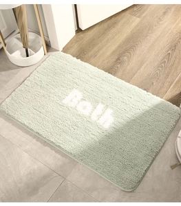 Detail of light green bath mat with Both embroidery on soft plush texture surface