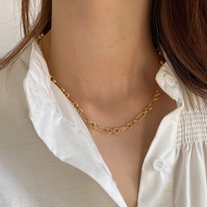 Close-up of a gold 925 silver circle chain necklace worn by a model in white