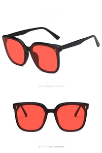 Front and side views of oversized black square sunglasses with vibrant red lenses