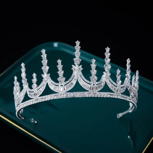 Macro view of bridal silver tiara with rhinestones on luxury dark green display tray
